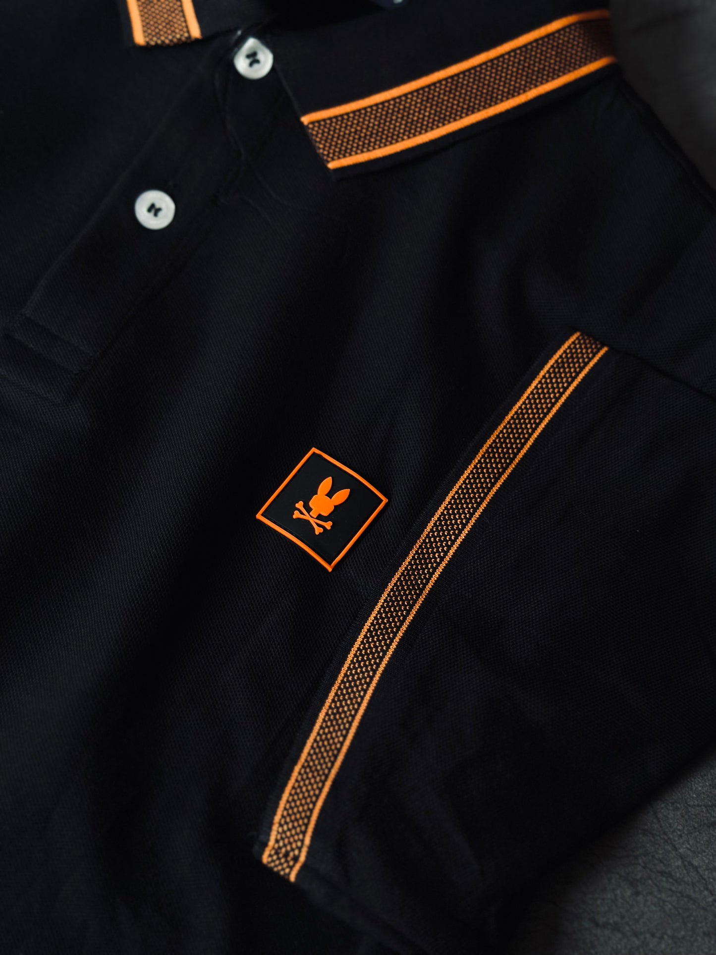 CAMISETA POLO PSY NEGRA CUELLO NARANJA