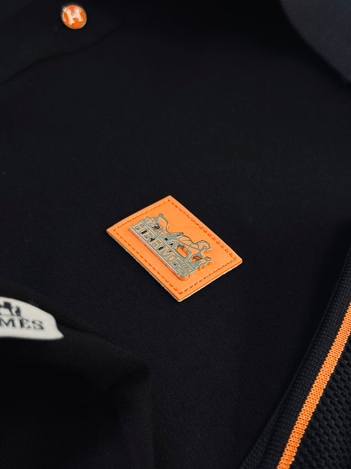 CAMISETA POLO HER NEGRA TEJIDO PLACA NARANJA