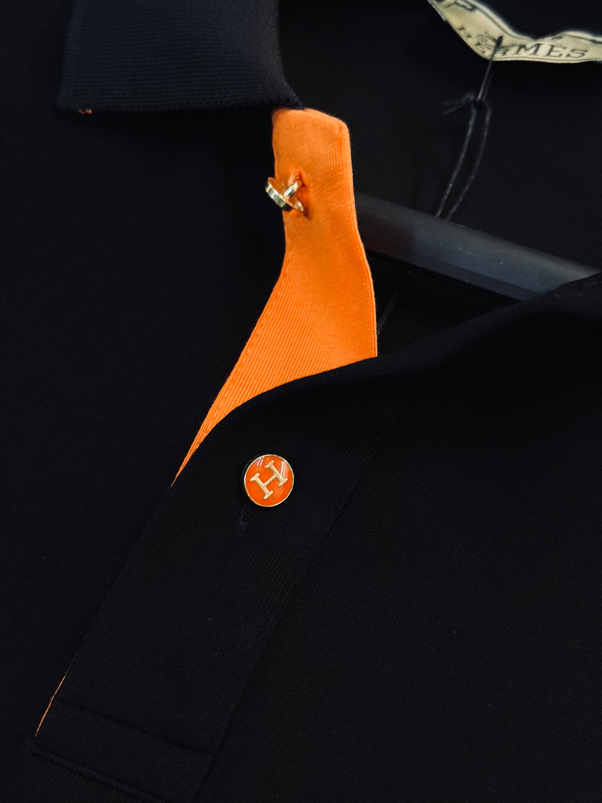 CAMISETA POLO HER NEGRA TEJIDO PLACA NARANJA