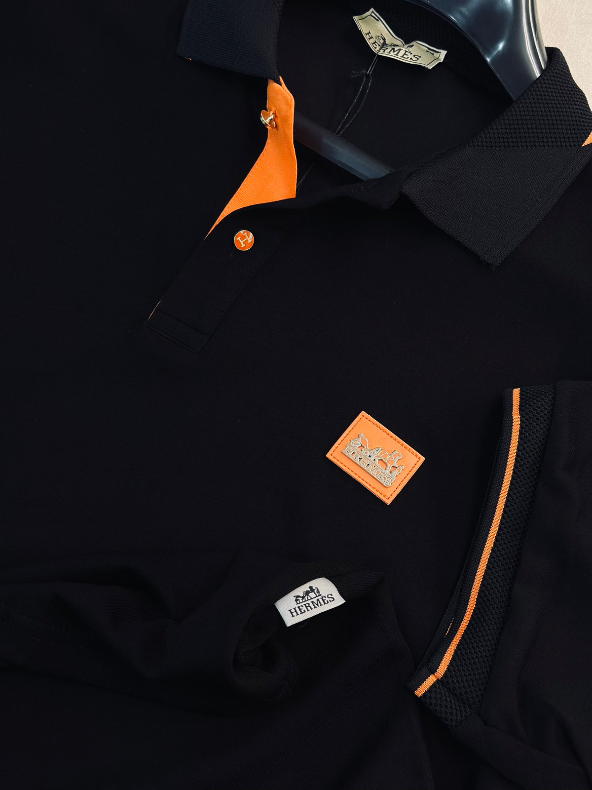 CAMISETA POLO HER NEGRA TEJIDO PLACA NARANJA