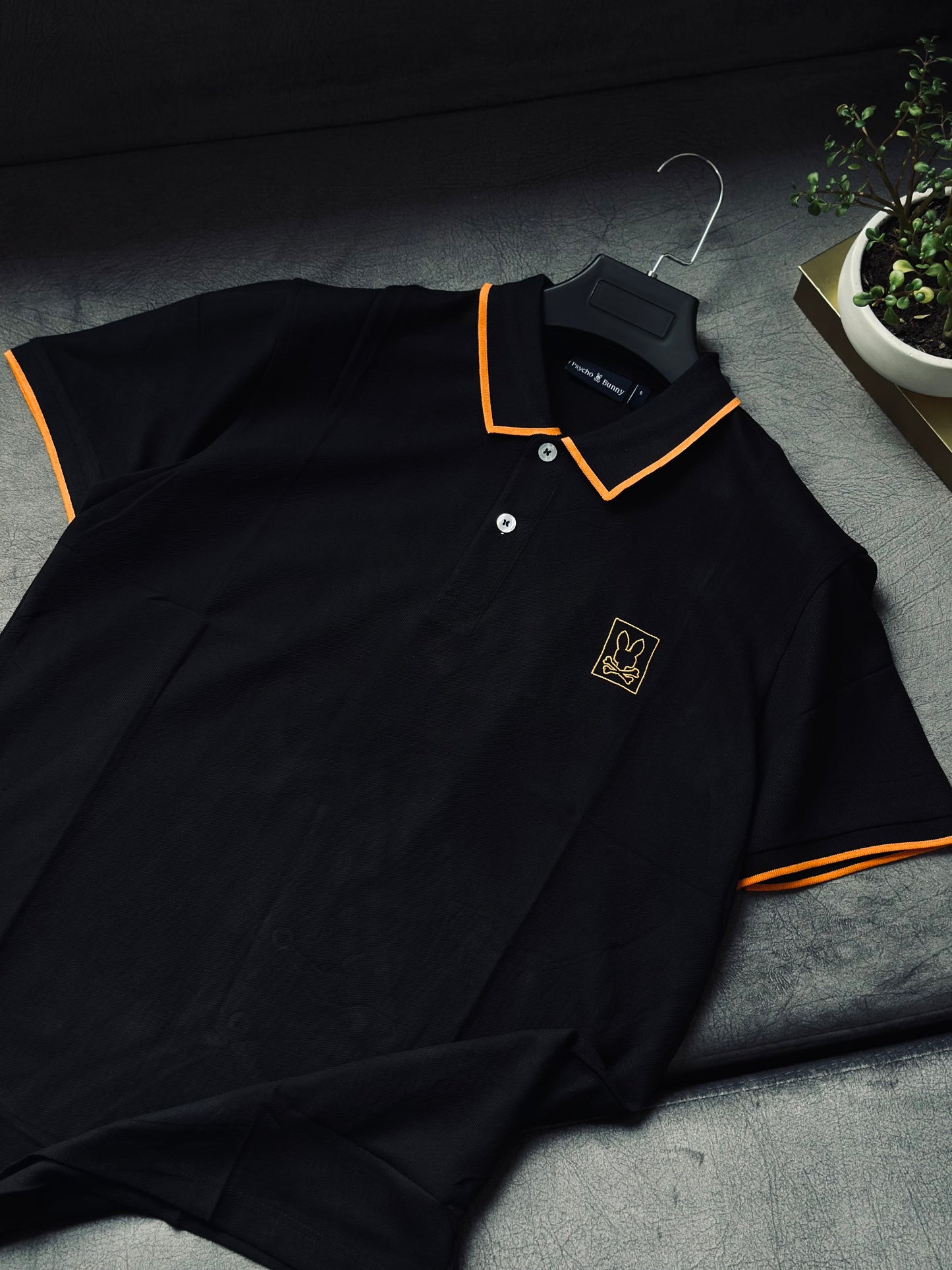 CAMISETA POLO PSY NEGRA BORDE NARANJA